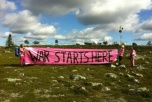 Bild på ofogaktivister inne på NEAT med banderoll "war starts here"