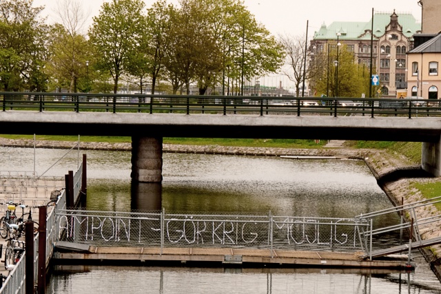 Text inflätad i ett brostaket: "Aimpoint - gör krig möjligt"