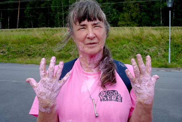 En kvinna i rosa t-shirt med rosa färg på händerna