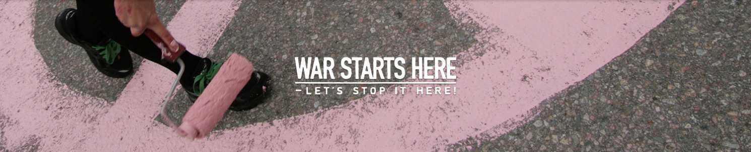 En roller målar rosa fredstecken på asfalt. War Starts Here's logotyp. 